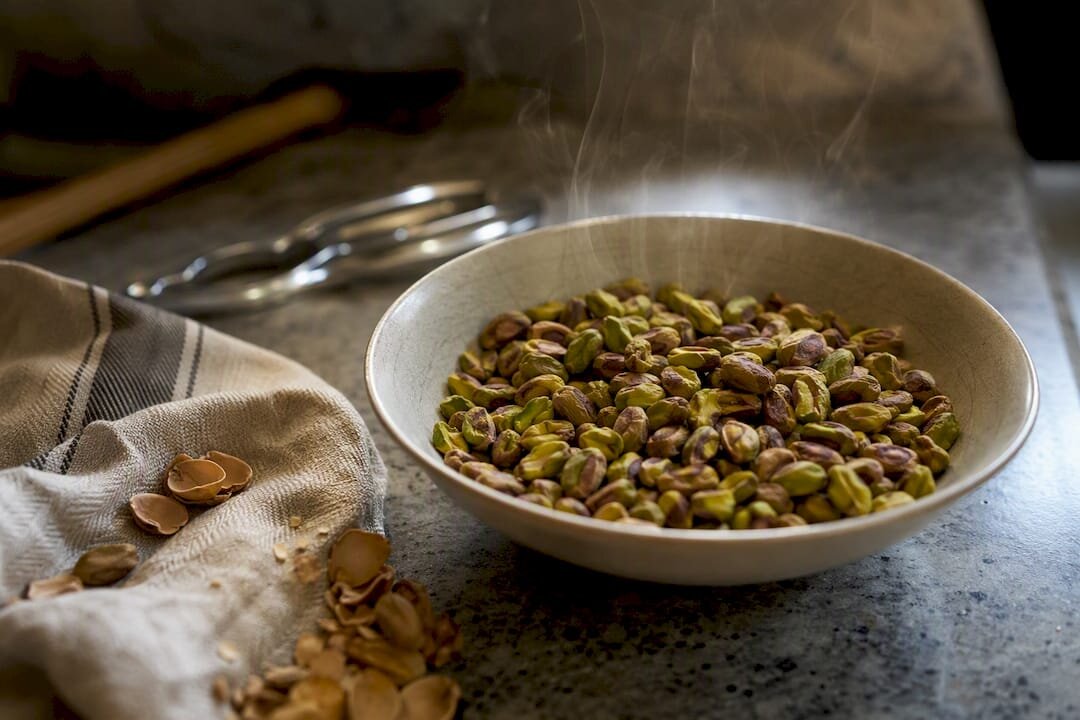 Un cuenco de pistachos recién tostados que aún echan vapor