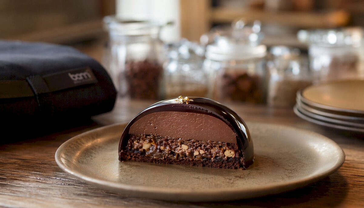 Primer plano de un postre en capas con una capa exterior de chocolate