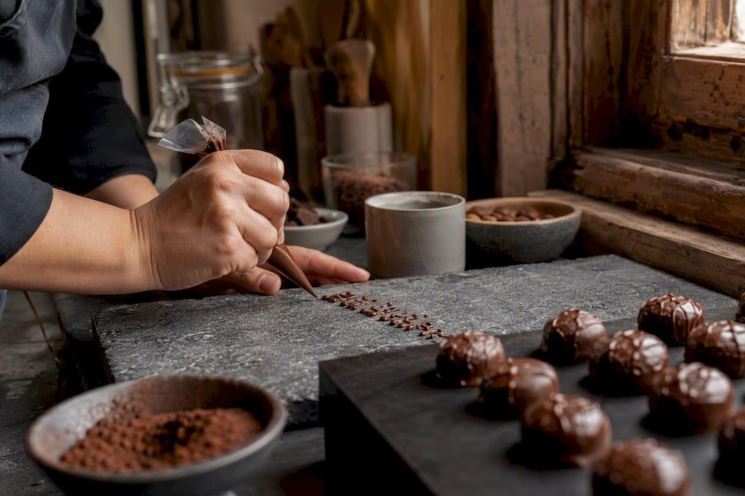 Manos decorando letras de chocolate personalizadas