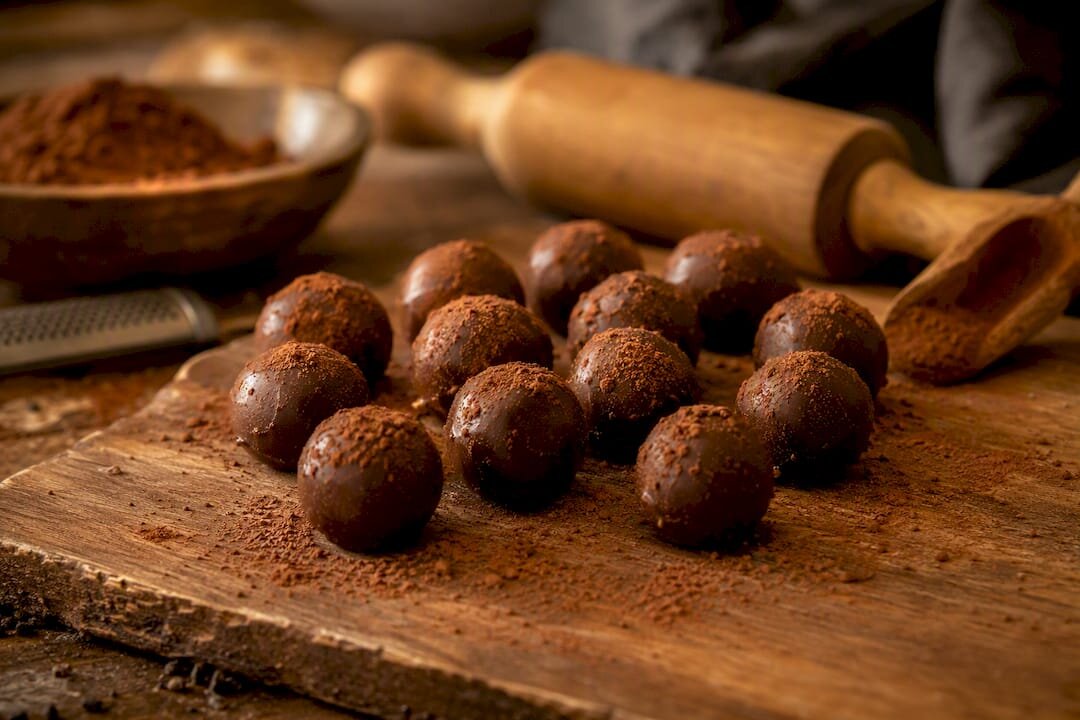 Trufas de chocolate enrolladas sobre una losa de mármol